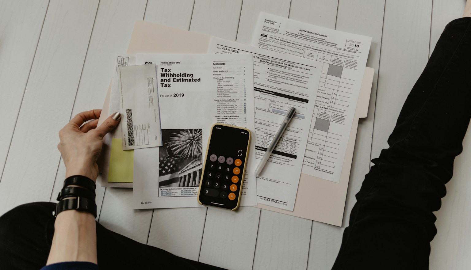 Business owner organizing tax forms, a calculator and financial papers