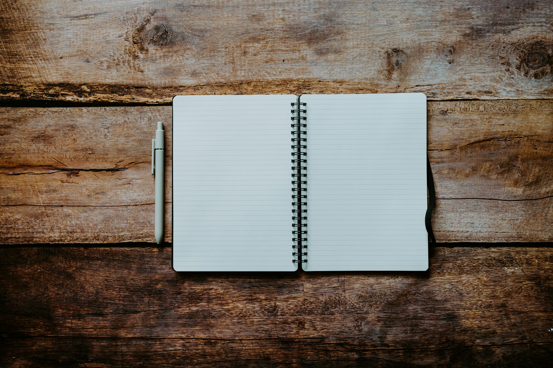 An open notebook and pen on a wooden table
