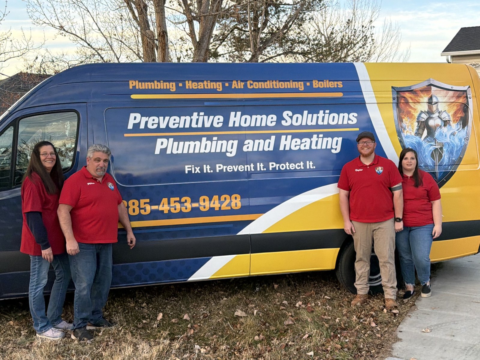 Preventive Home Solutions team standing beside their plumbing, heating and air service vehicle
