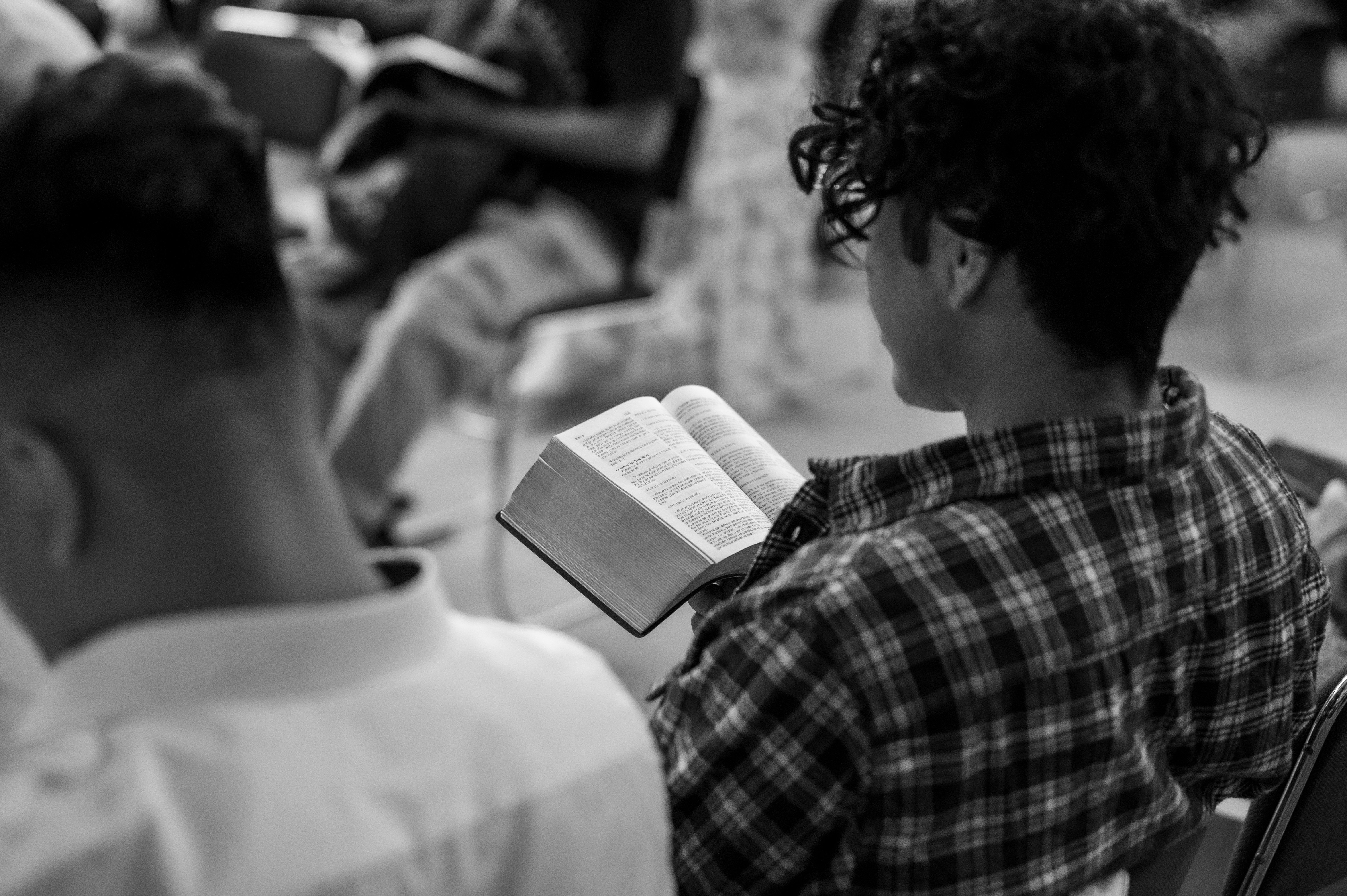 Personas reunidas leyendo la Biblia durante un tiempo de adoración