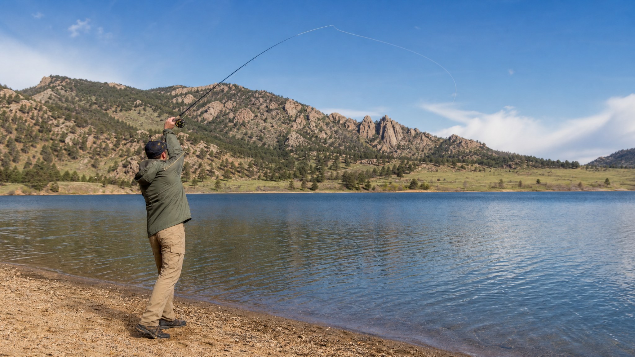 An angler casting from the shore of a Colorado mountain lake