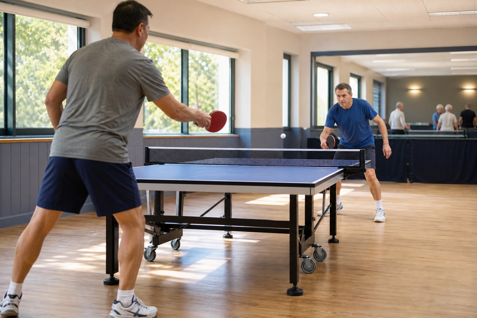 Two players practicing table tennis in an indoor club