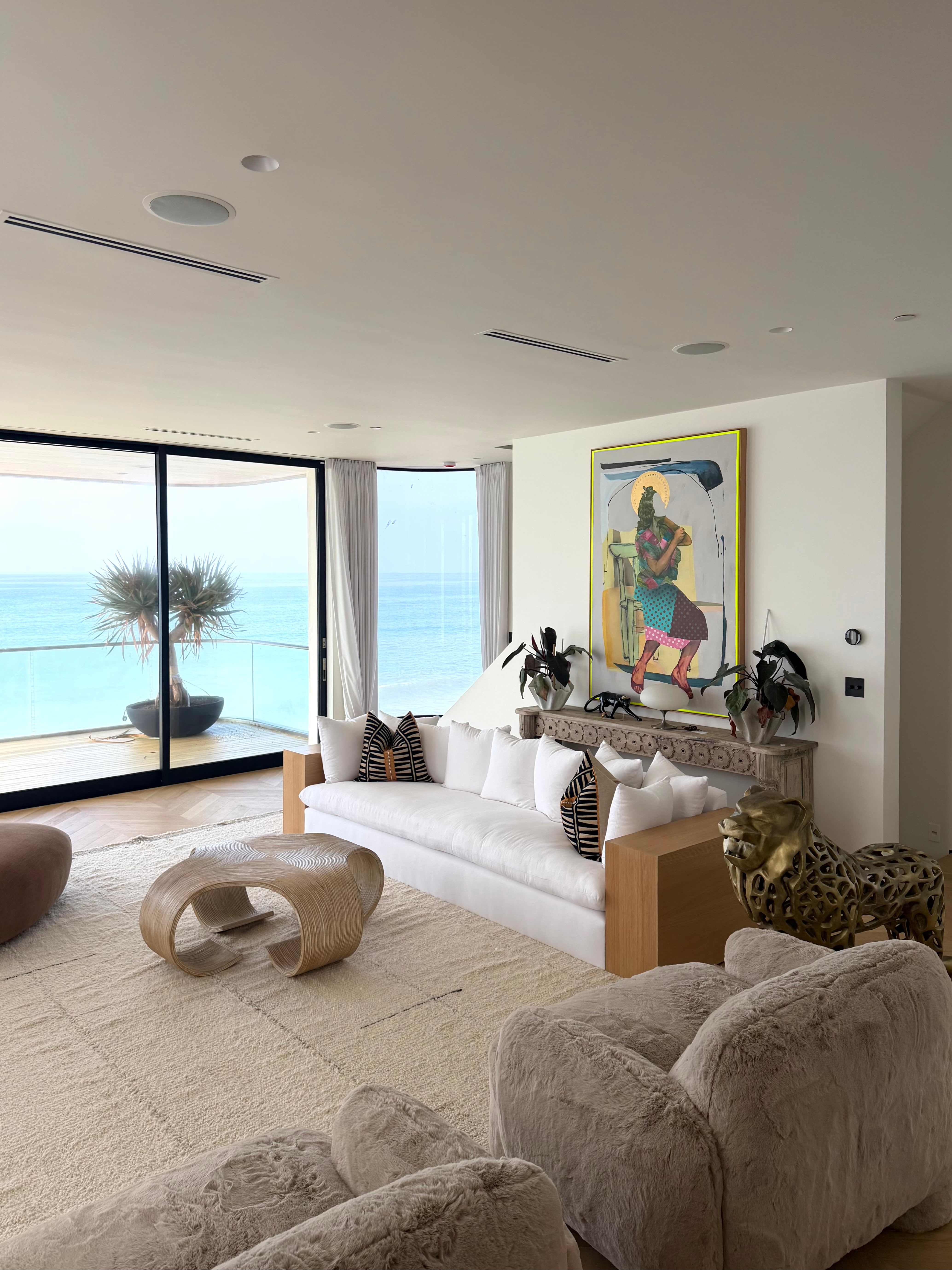 Living room at the Malibu Residence with ocean views, a white sofa, and collected furnishings