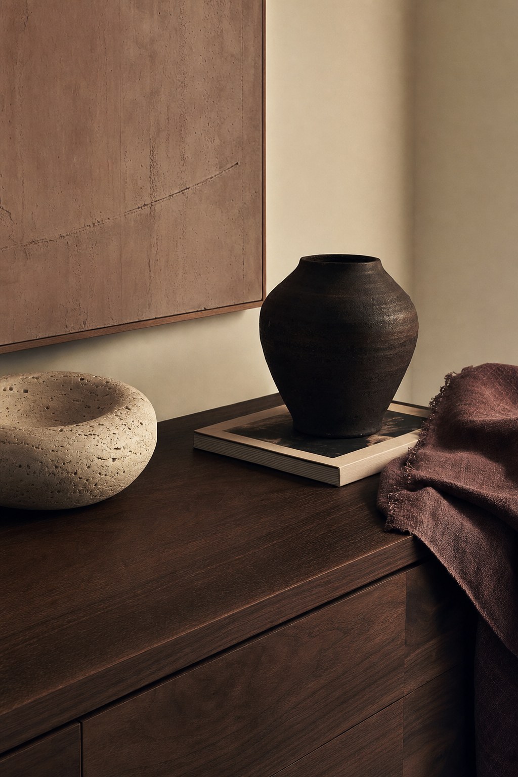 Tactile composition of dark ceramic, stone, walnut, and woven textile