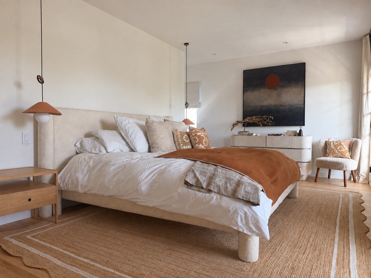 Warm bedroom with layered textiles, tailored upholstered furnishings, and a sculptural light