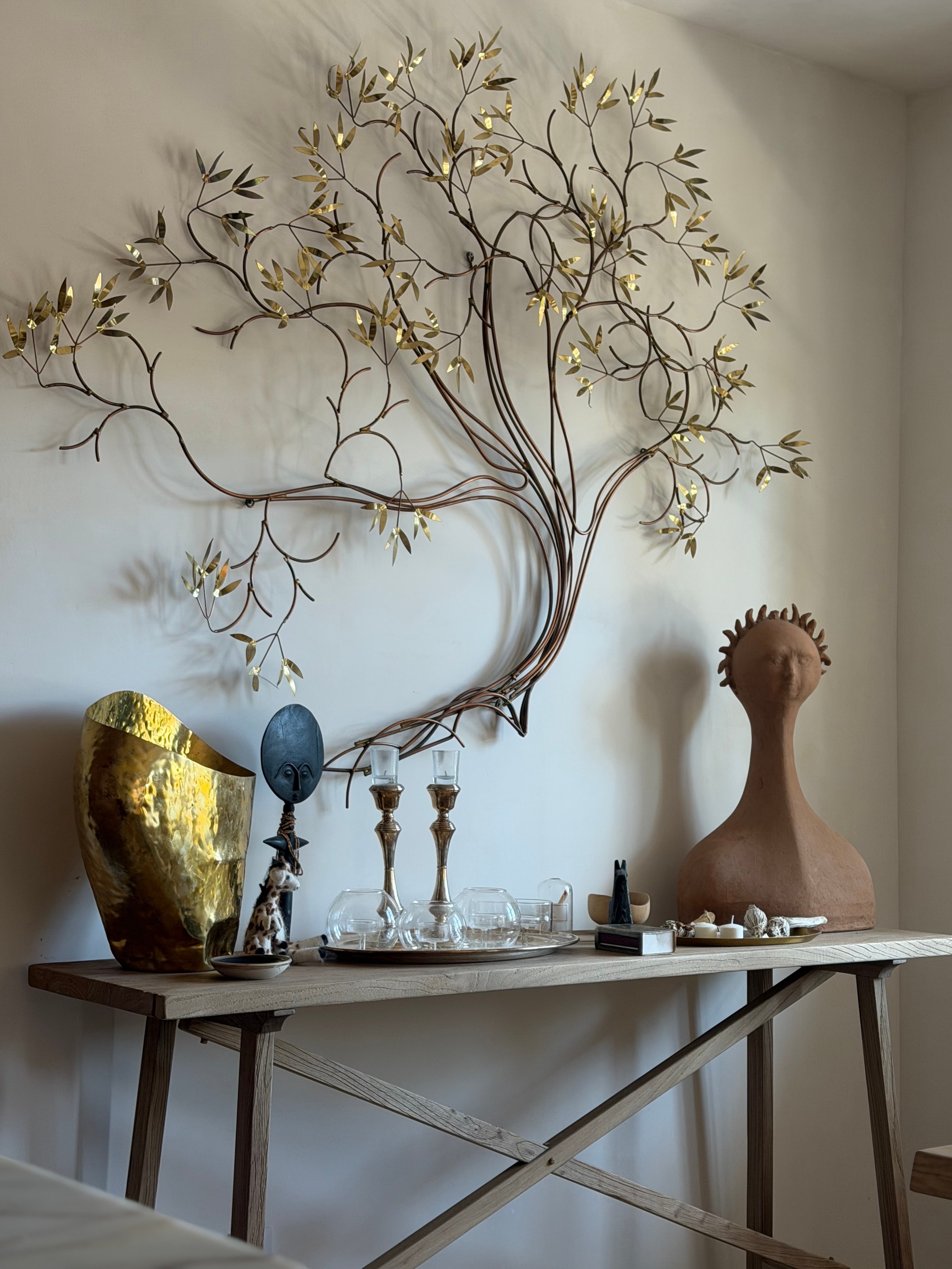 Sculptural wall art and collected objects showing how individual elements create a layered interior