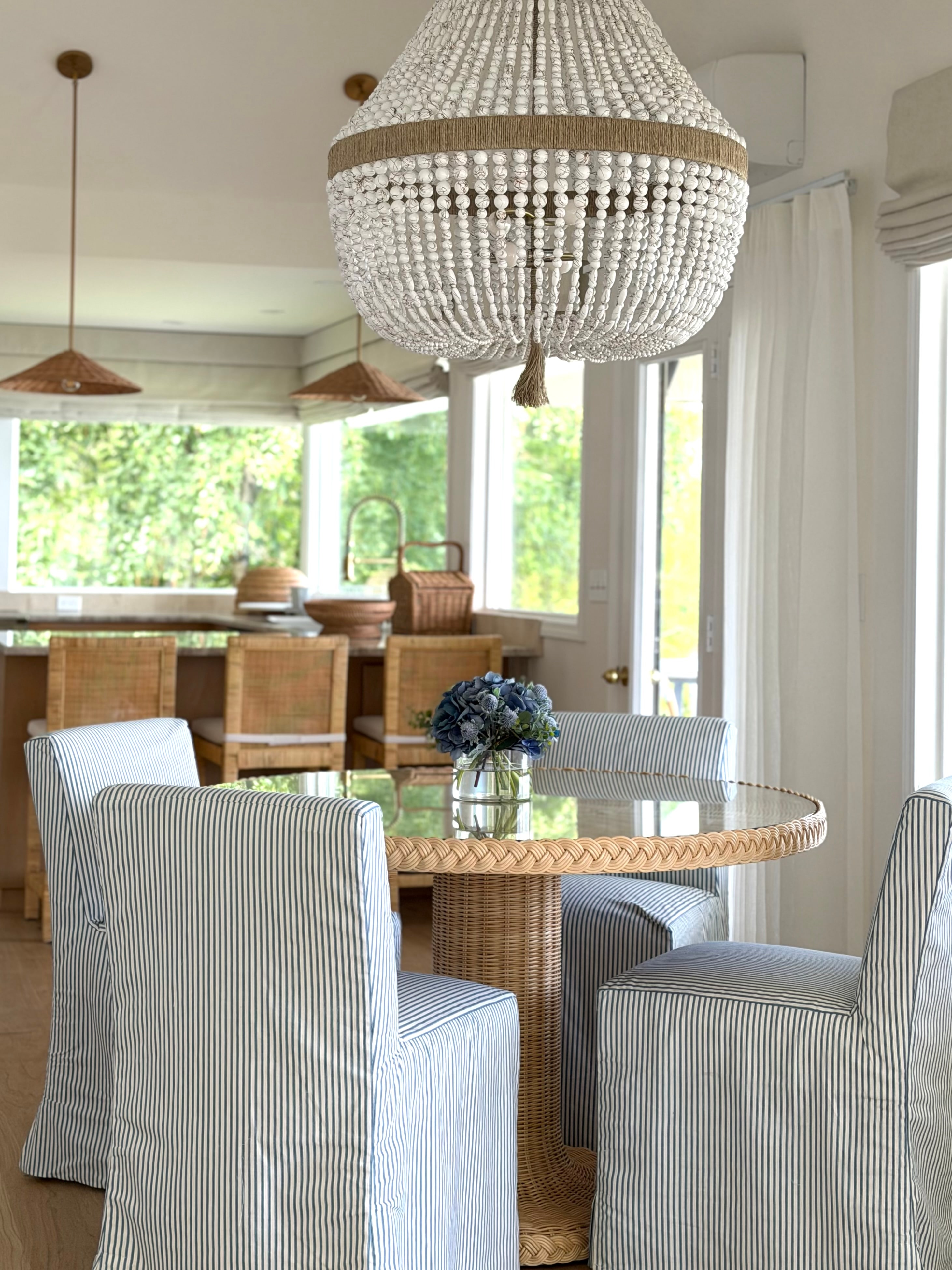 Idaho Lakeside Retreat dining detail with striped chairs, braided rattan table, and a beaded chandelier