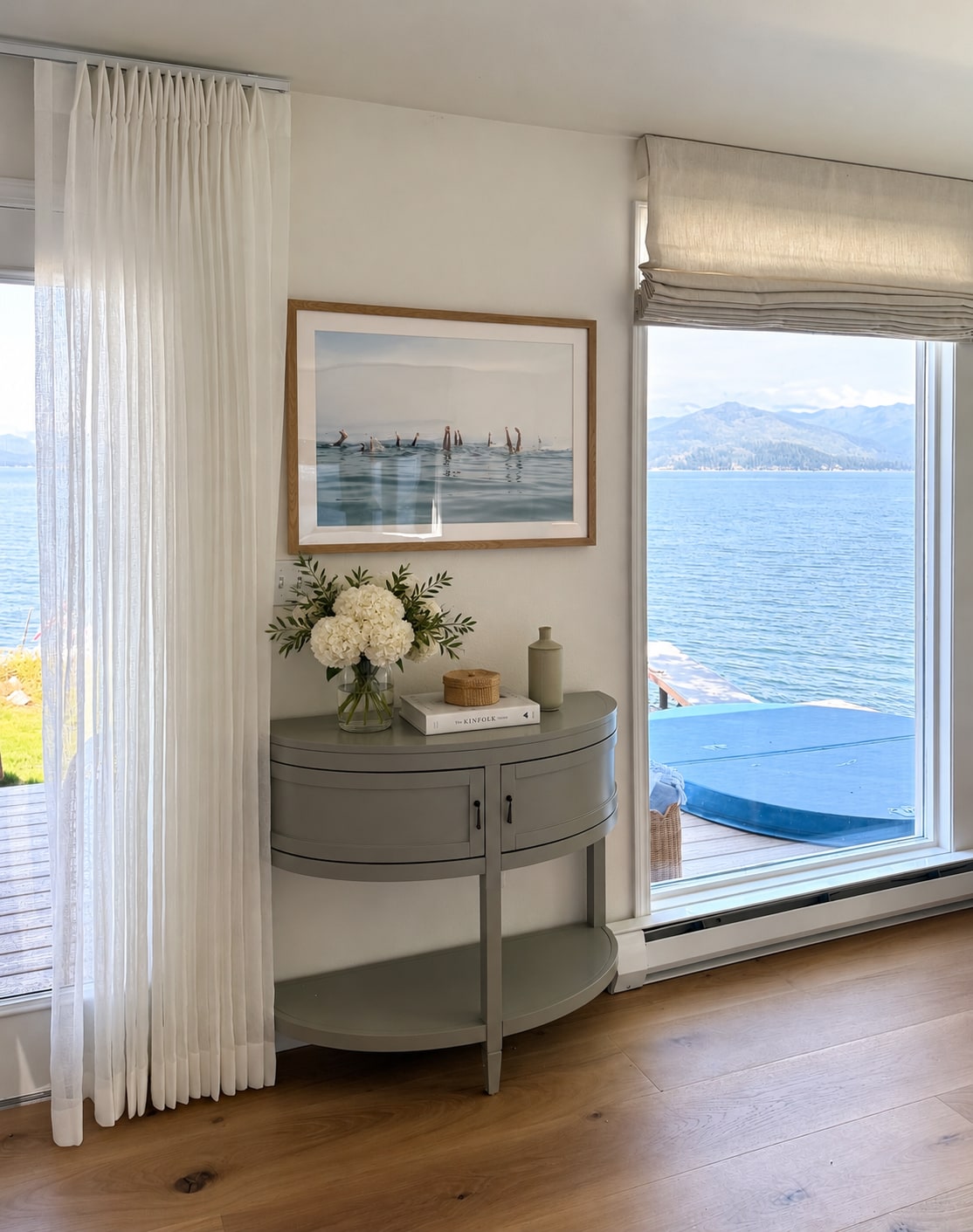 Idaho Lakeside Retreat lakeside console with white flowers, sheer curtains, and mountain views