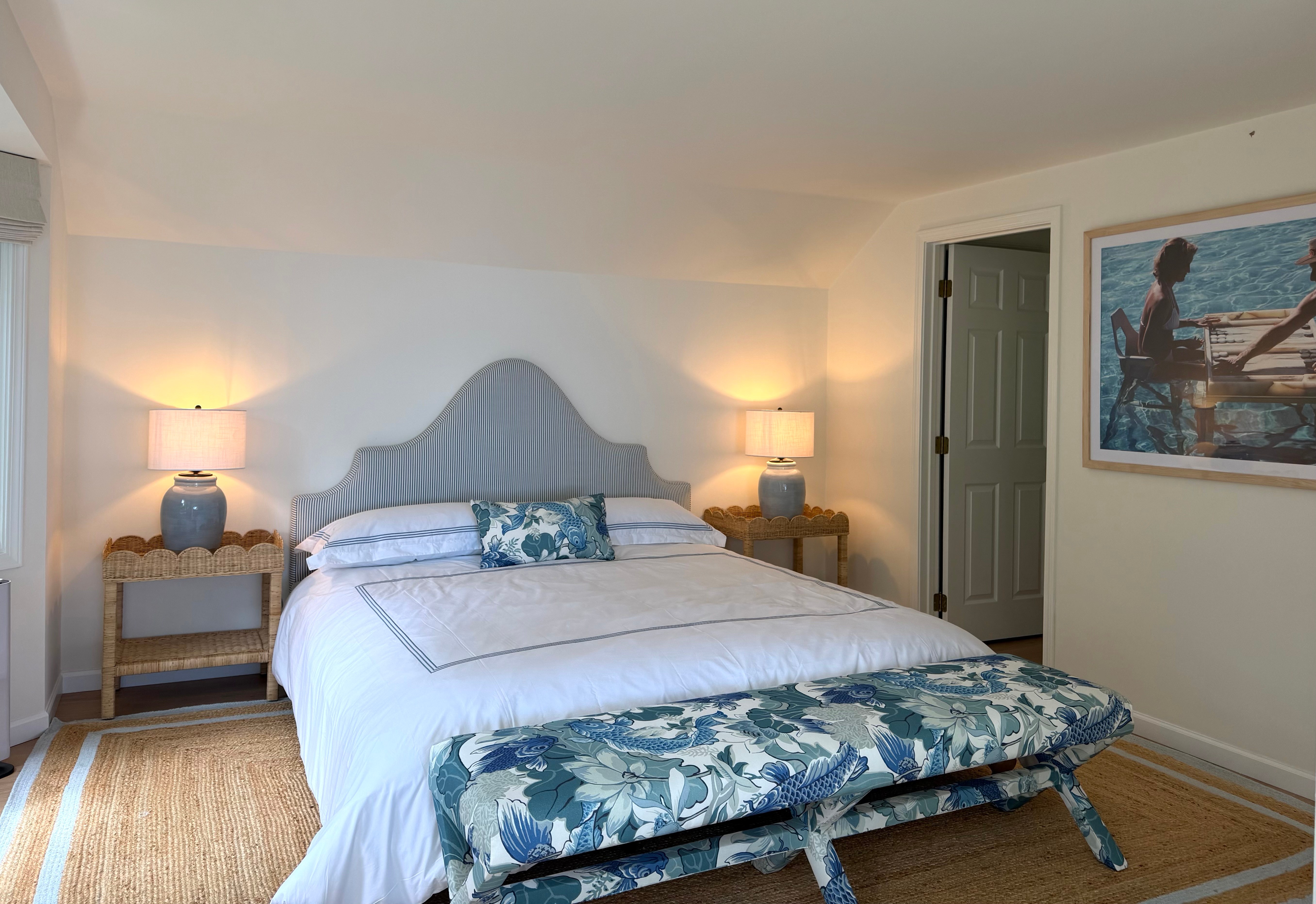 Idaho Lakeside Retreat primary bedroom with blue floral upholstery, woven bedside tables, and a patterned bench
