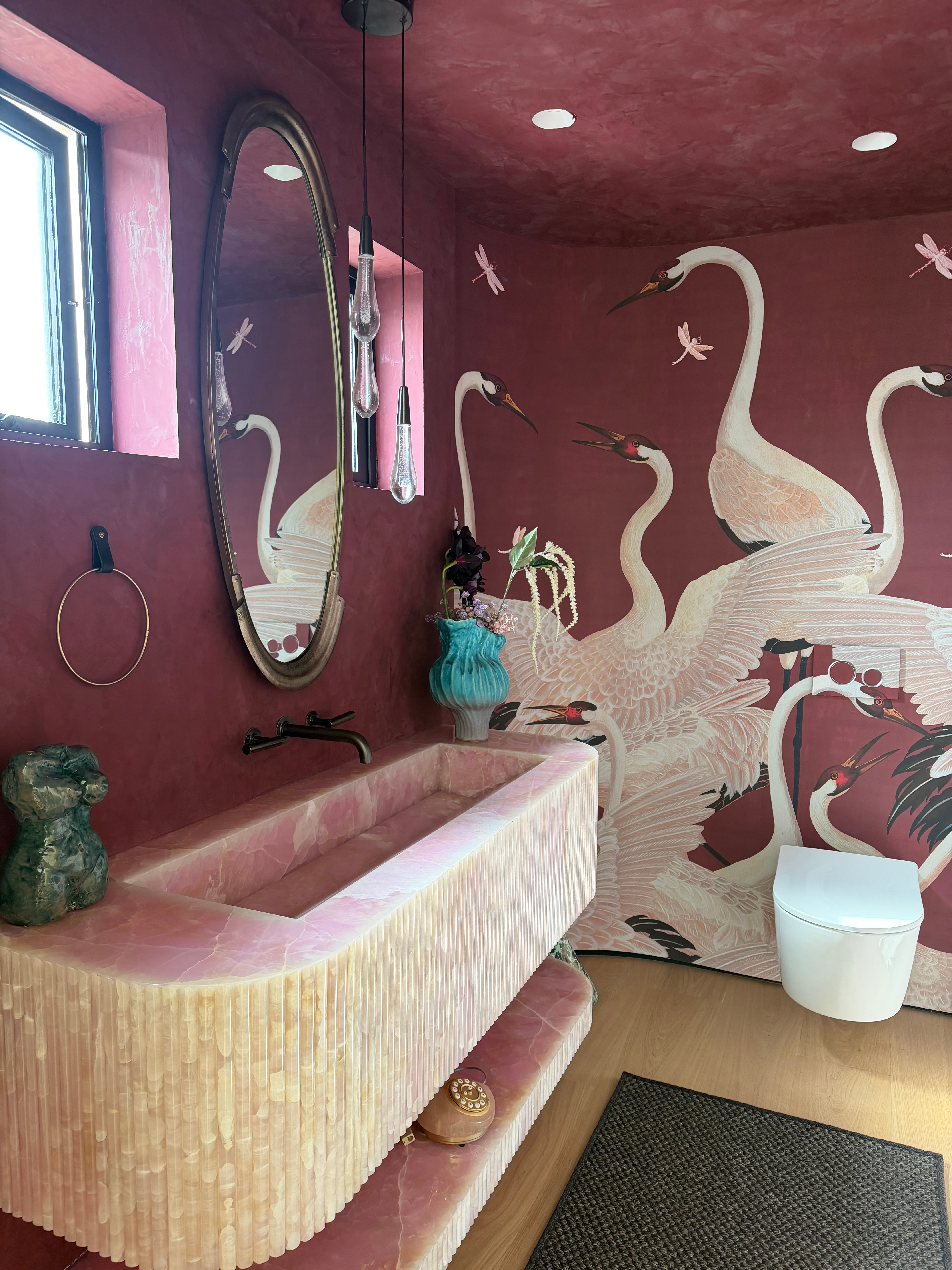 Malibu Residence powder room with a pink onyx stone basin and hand-painted crane mural