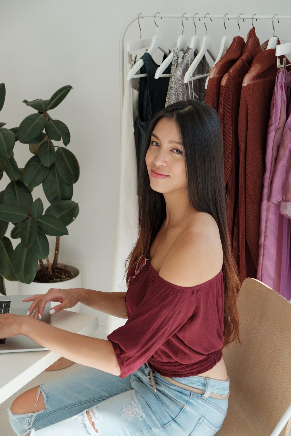 A woman choosing her style beside a rack of clothing