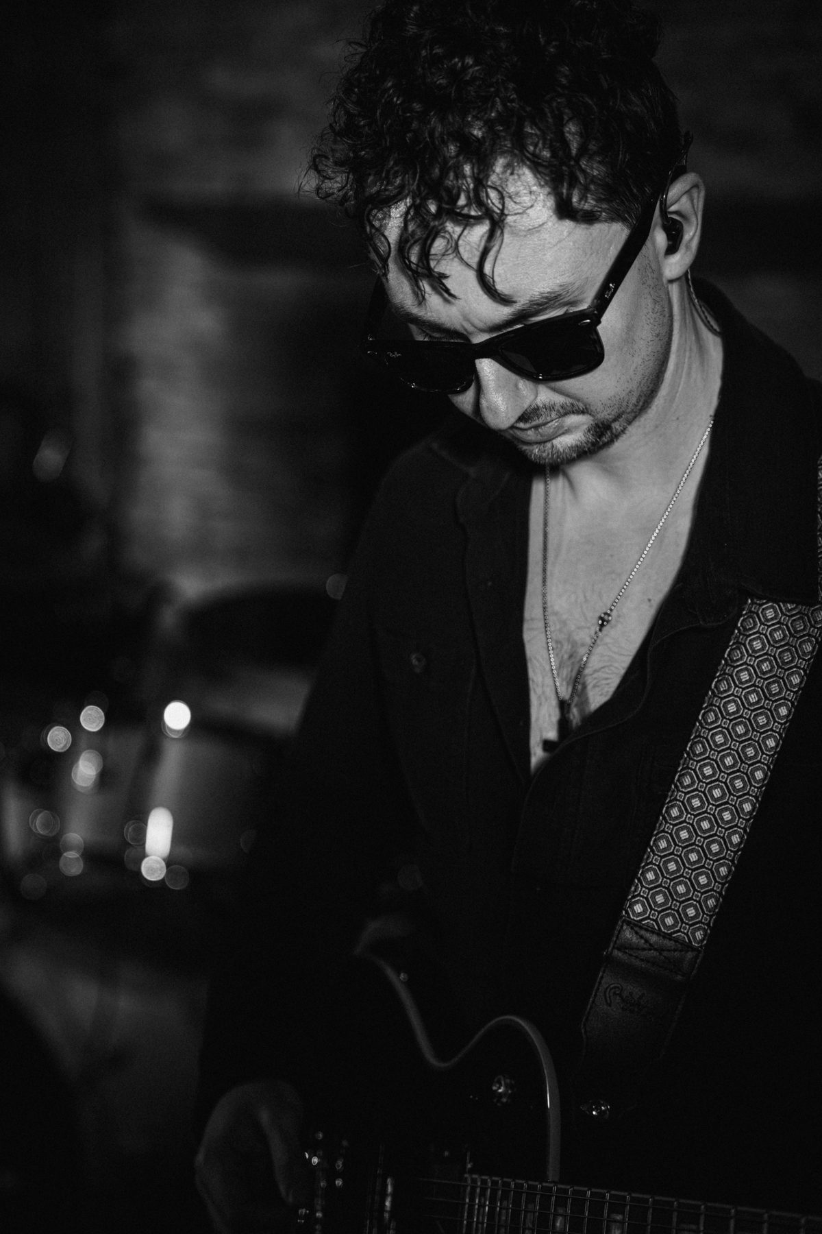 The Wonderwall guitarist performing in a dark club