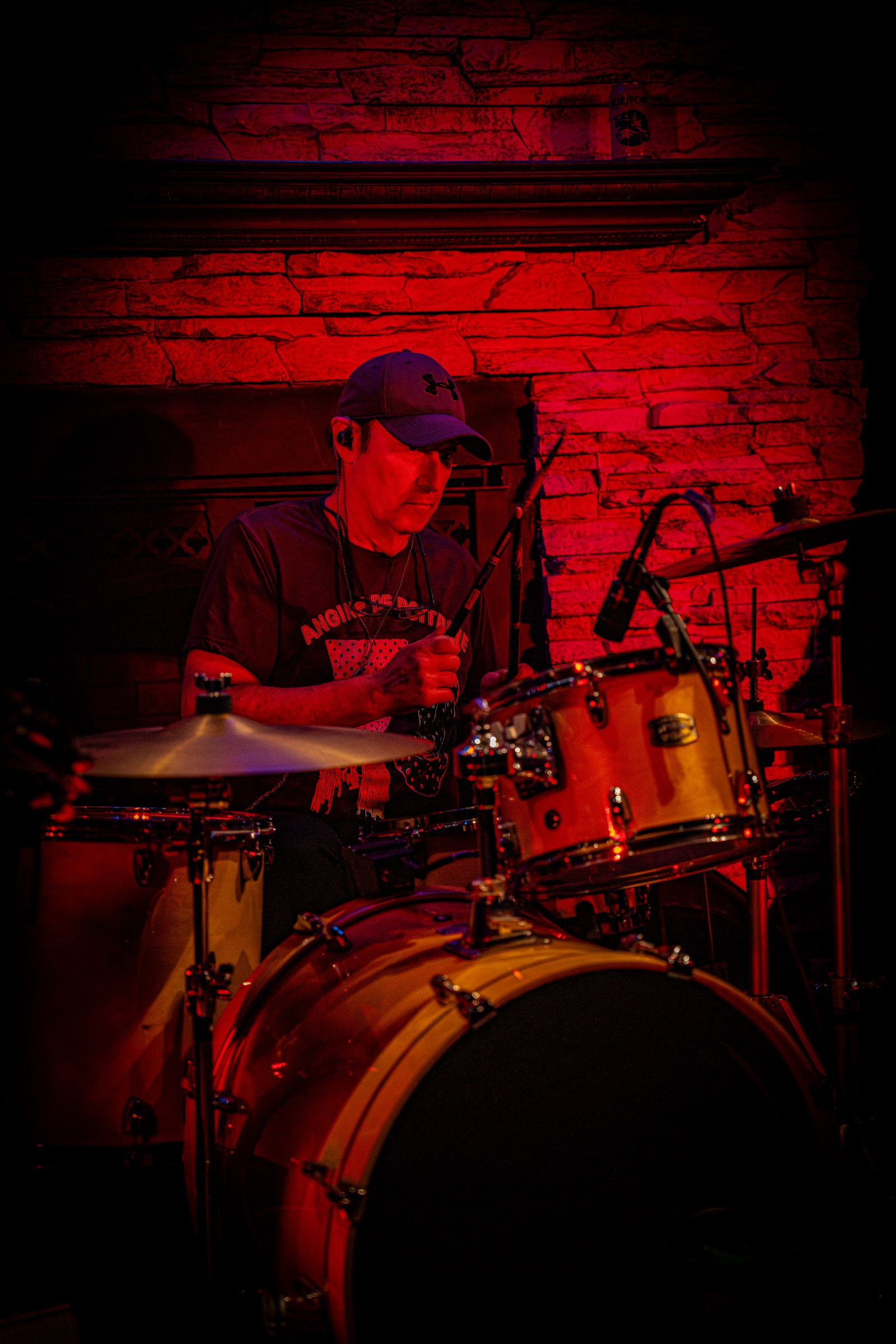 Drummer performing behind the kit under stage lights