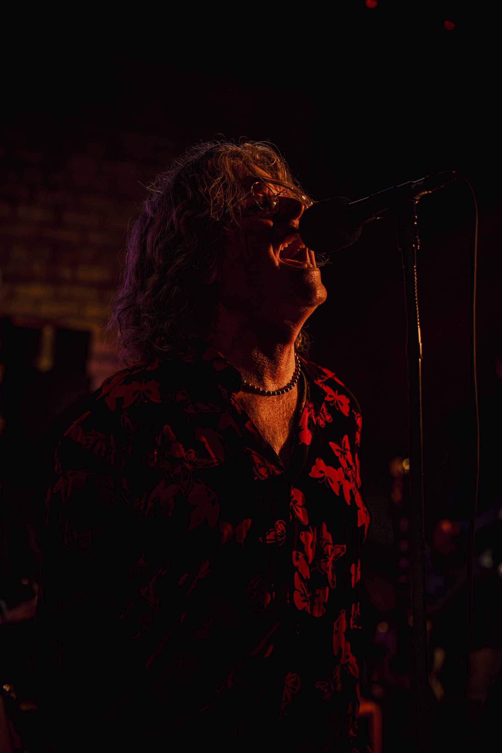 The Wonderwall singer on stage wearing sunglasses