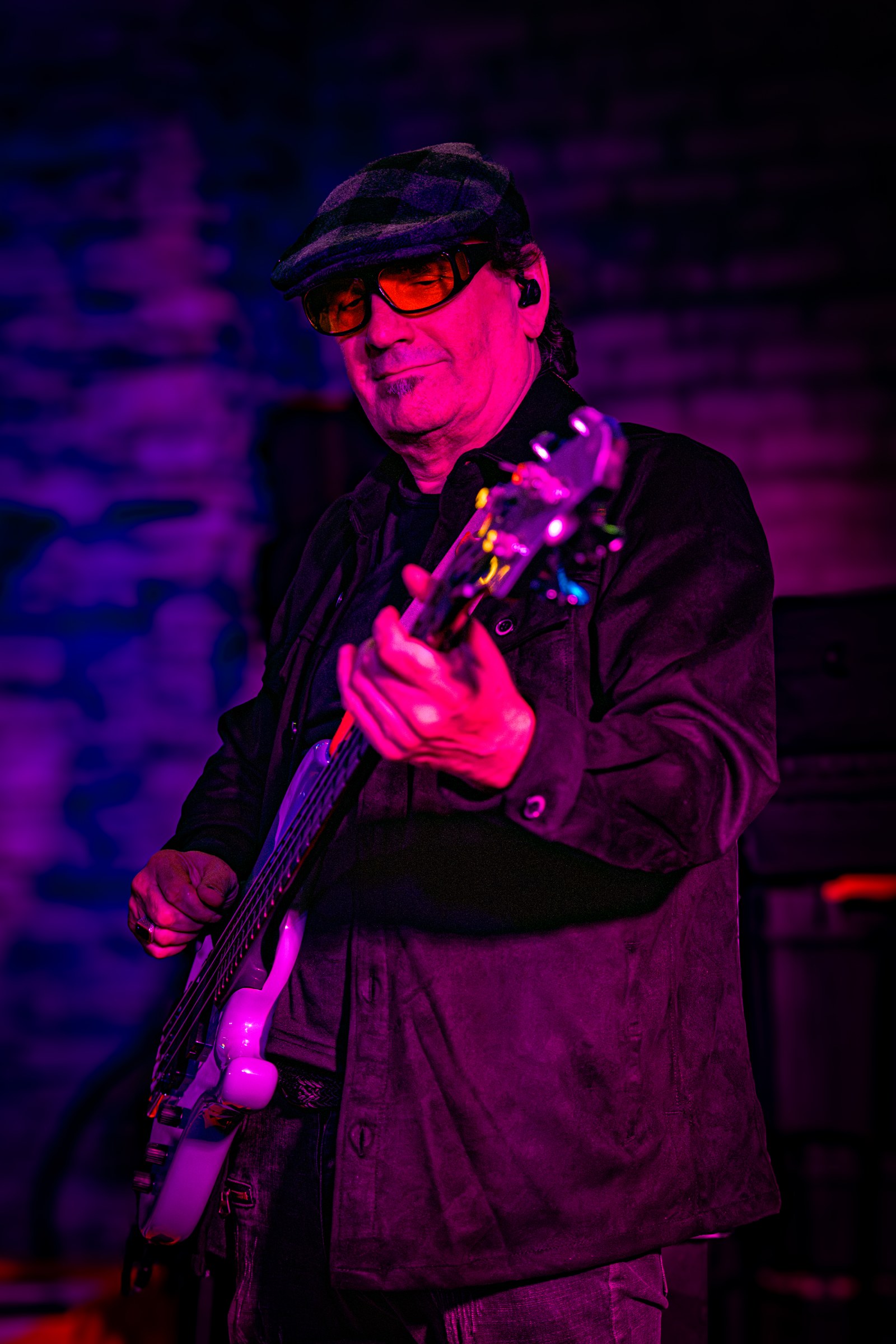 Bassist performing under purple stage lights