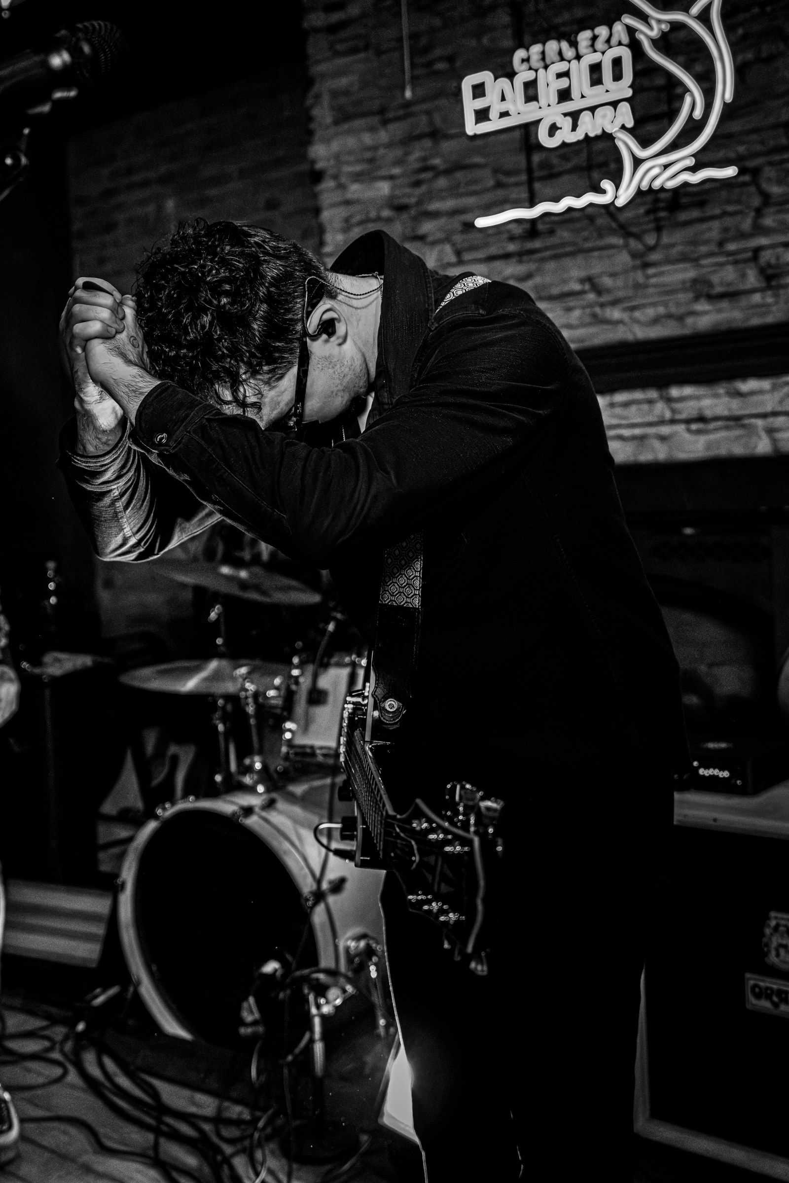 Black-and-white photo of the singer beside the drum kit