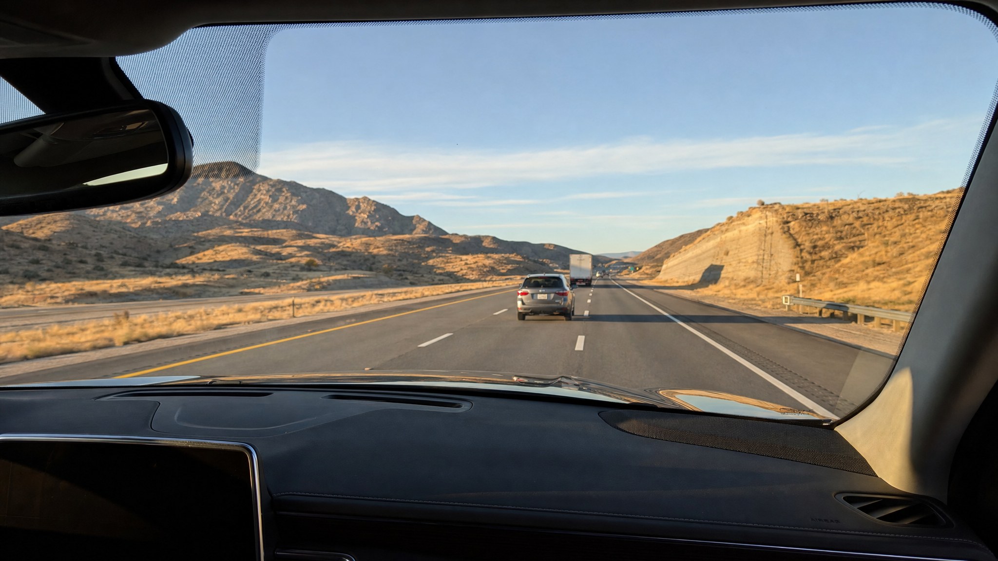 Driver's view through a clear windshield on an open highway