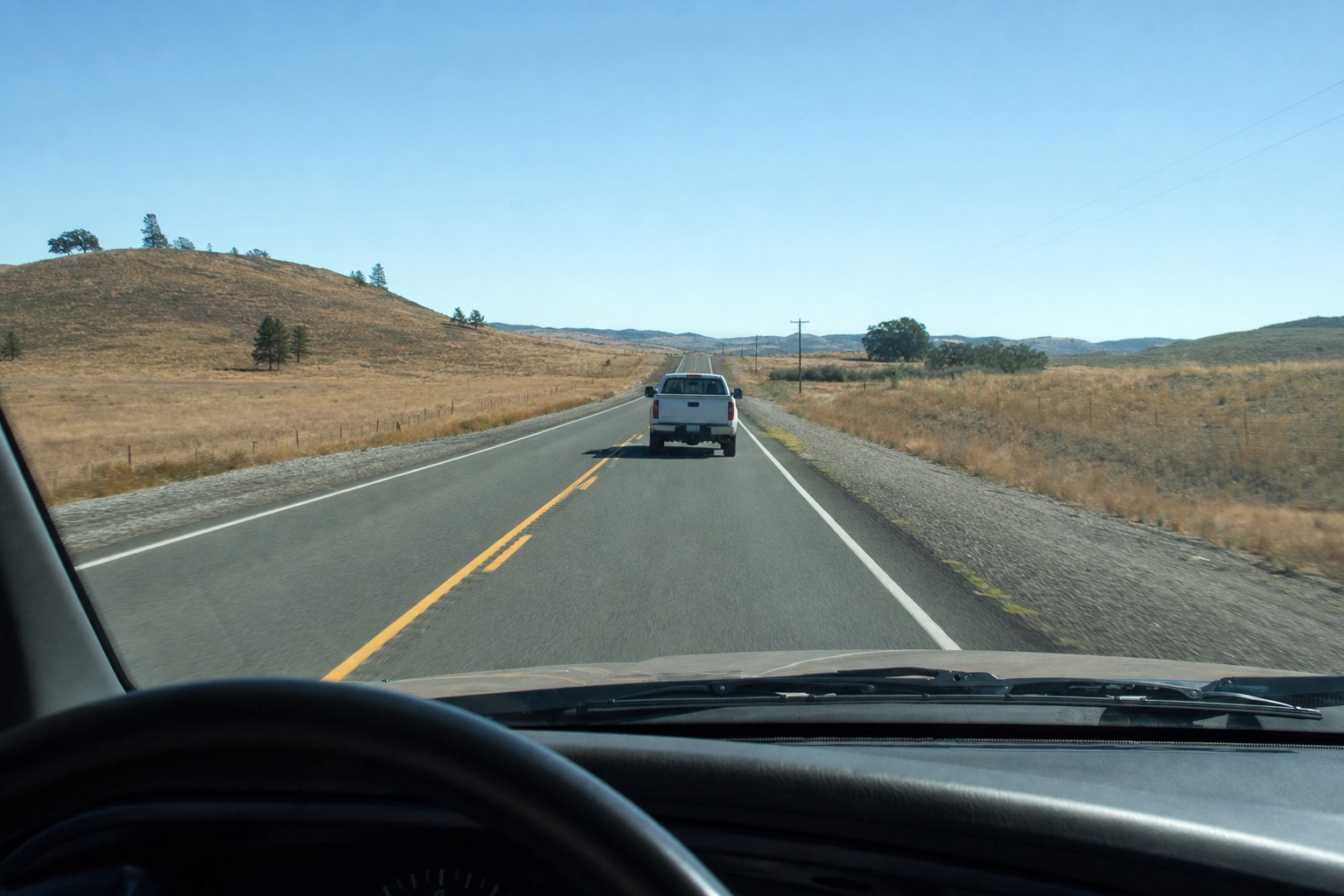 Driver view through a clear windshield on a rural highway