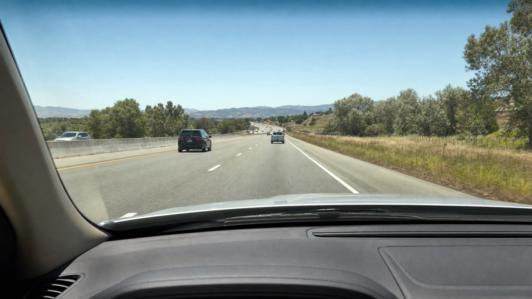 Clear driver view through an SUV windshield on an open highway