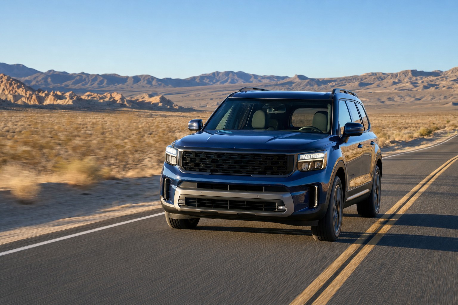 Dark blue SUV driving on an open highway with a clear windshield