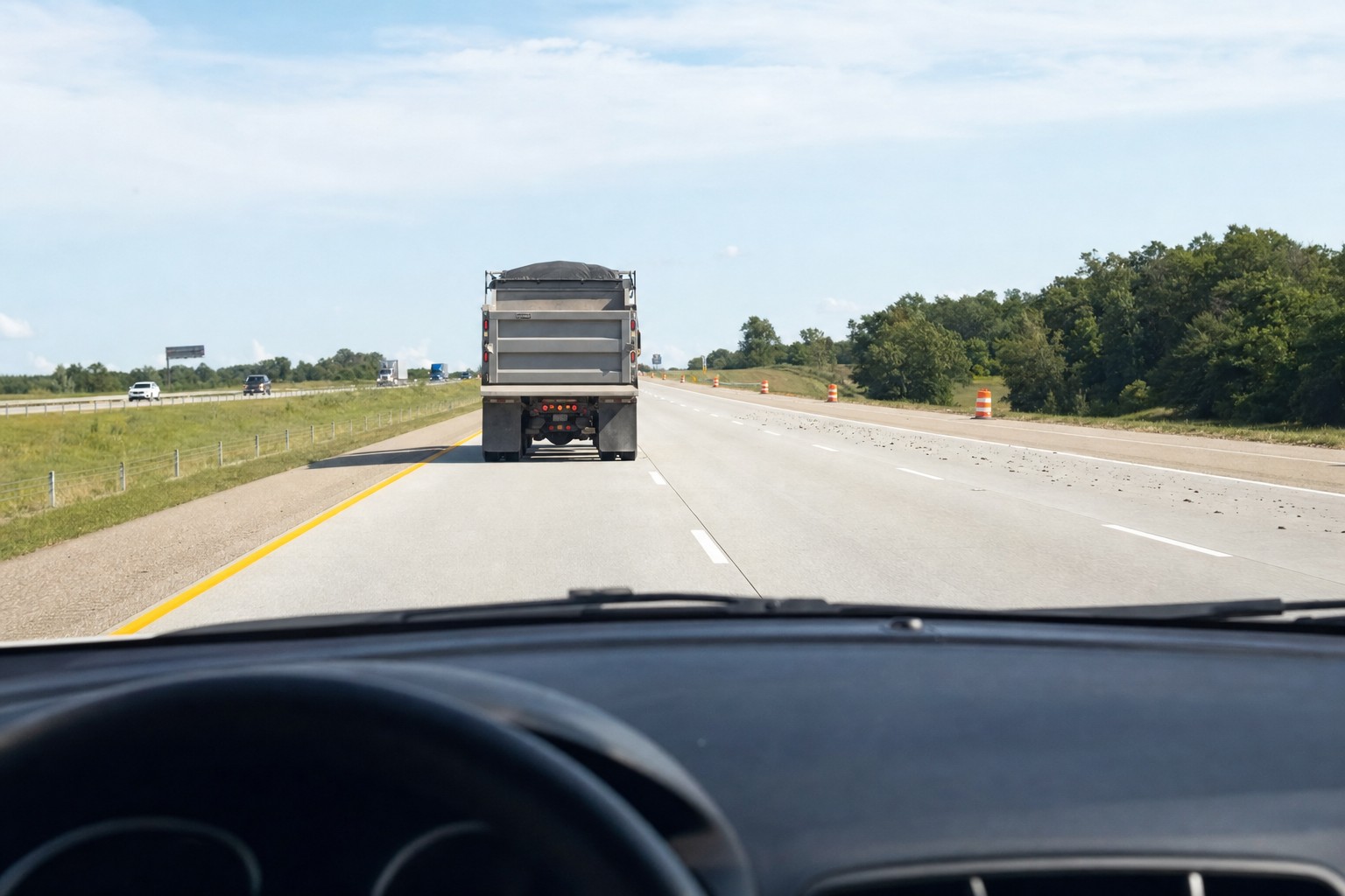 Driver view through a clear windshield on a highway behind a truck