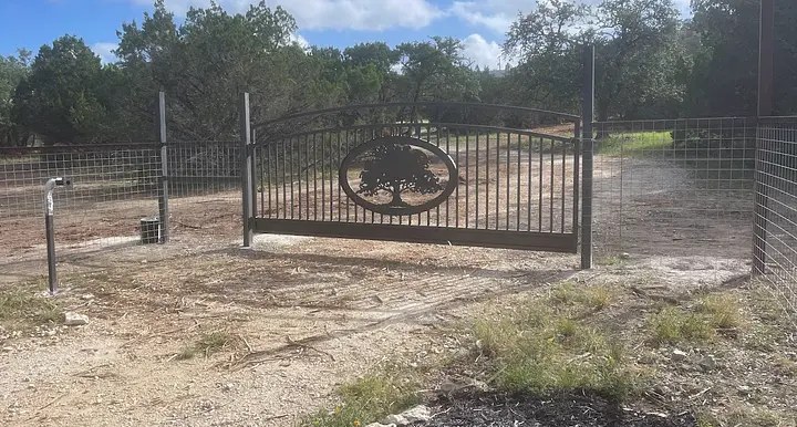 Black custom steel gate at a Texas Hill Country entrance