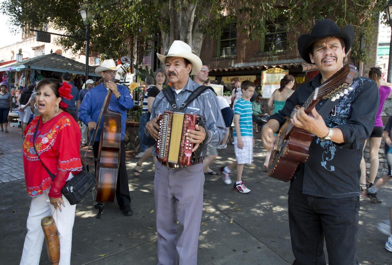 Street musicians singing and playing double bass, accordion, and guitar on Olvera Street in 2012