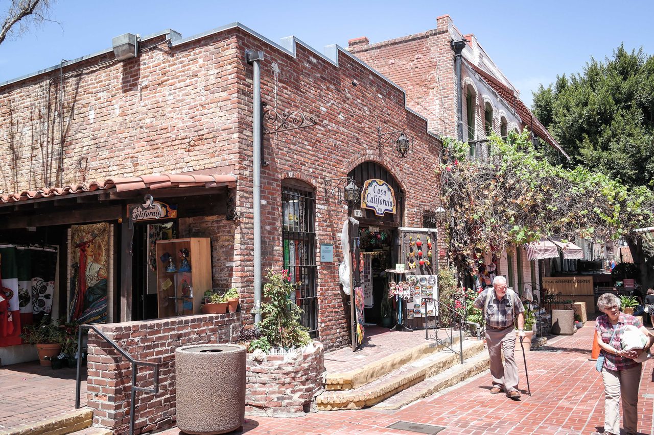 Historic brick storefronts and pedestrians along Olvera Street in 2014