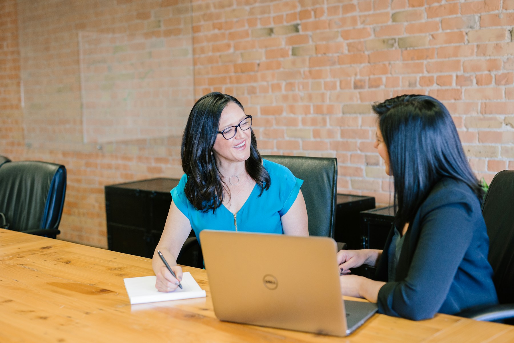 Two colleagues reviewing notes and preparation at a meeting table