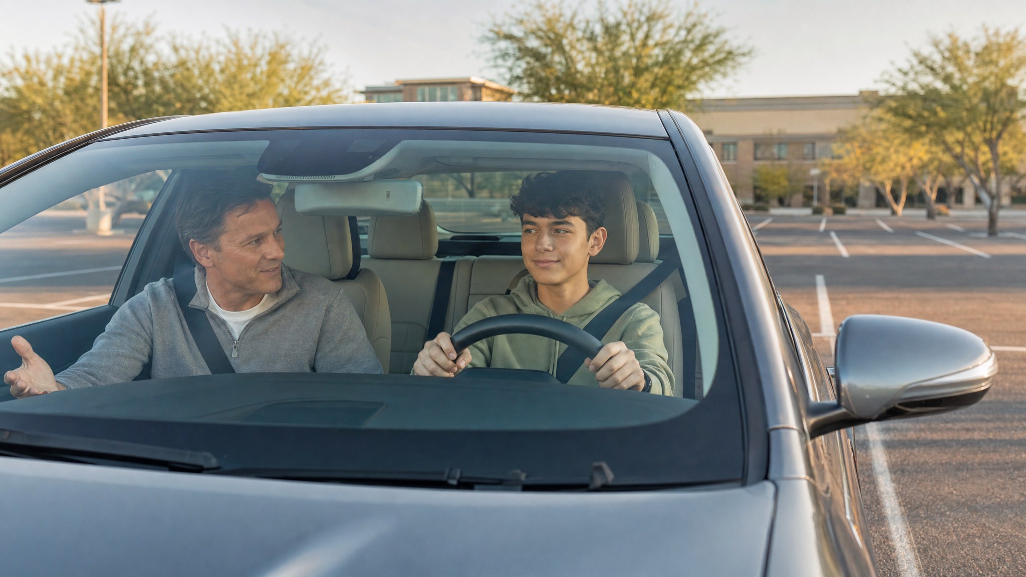 Teen driver practicing calmly with a supportive parent in a parked car