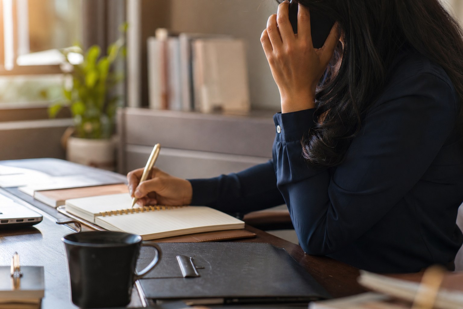 Professional making a thoughtful follow-up phone call while taking notes