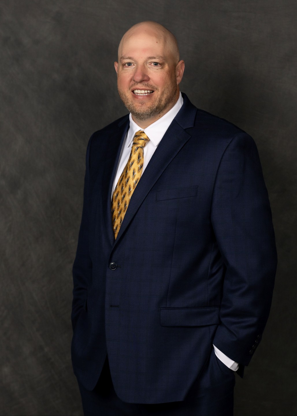 Coach Fin in a navy suit and gold tie