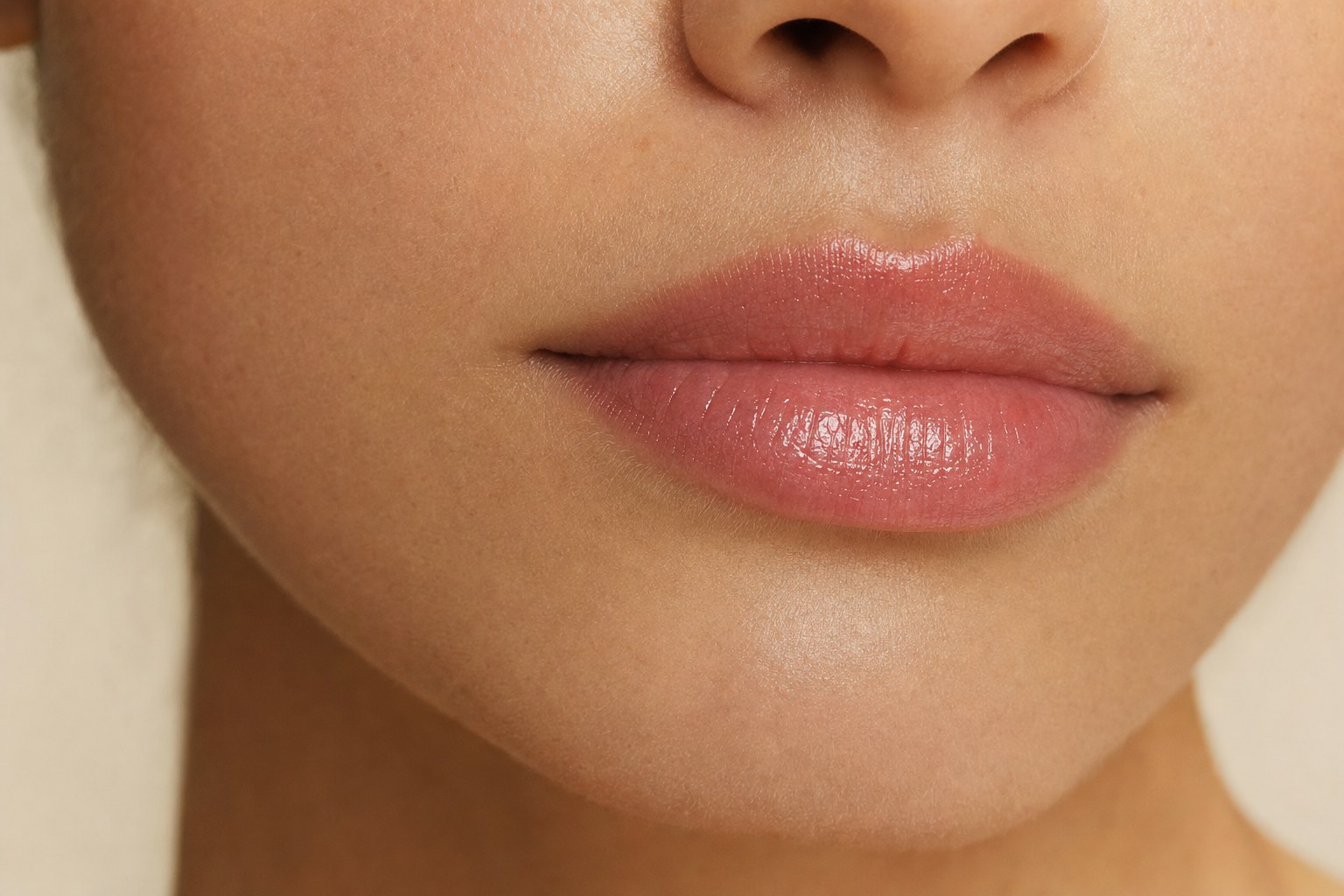 Soft nude lips with a sheer, glossy finish and a clean natural edge