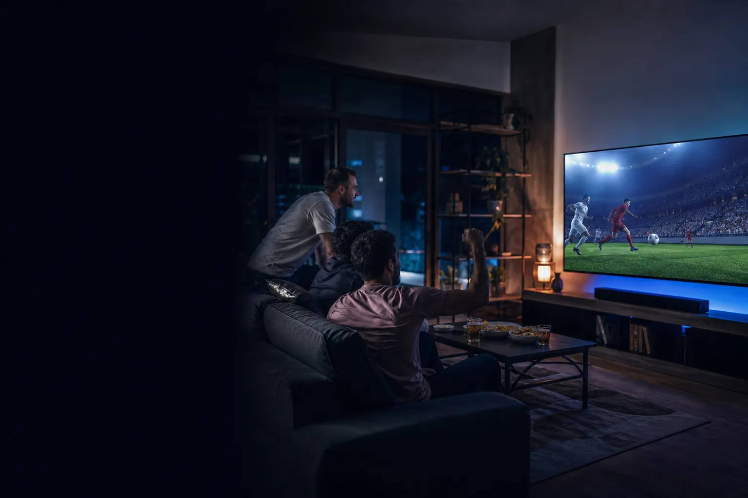 Friends watching a live football game together in a modern living room