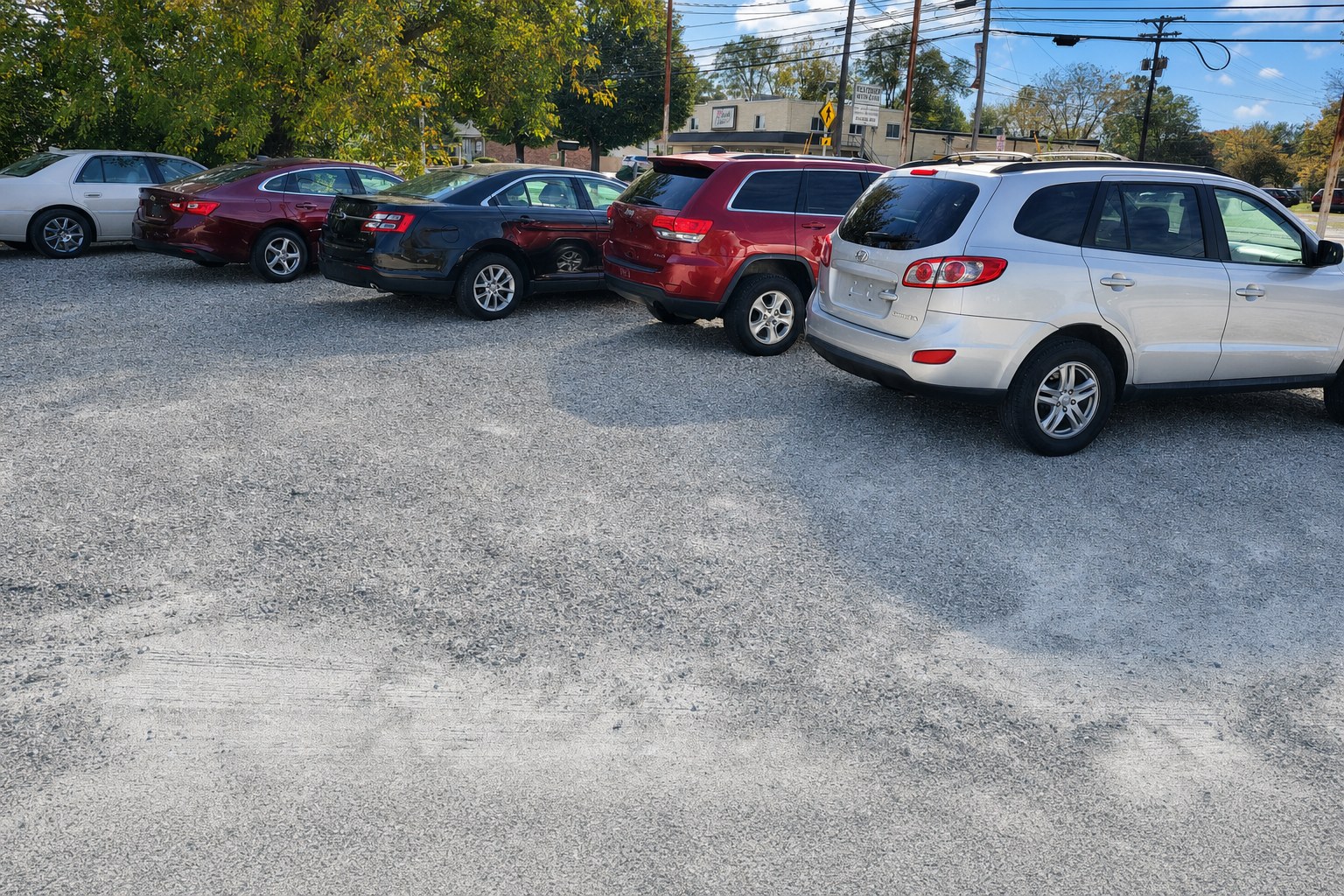 Vehicles lined up at the First Choice Motors Inc gravel lot