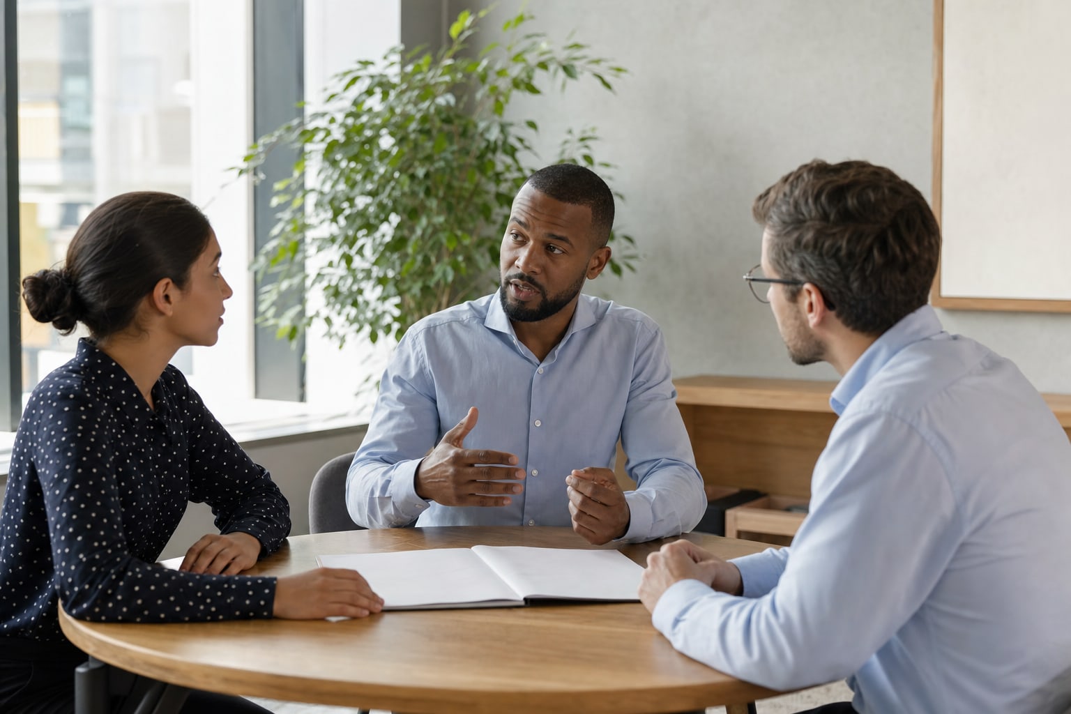 Manager leading a focused conversation with two colleagues