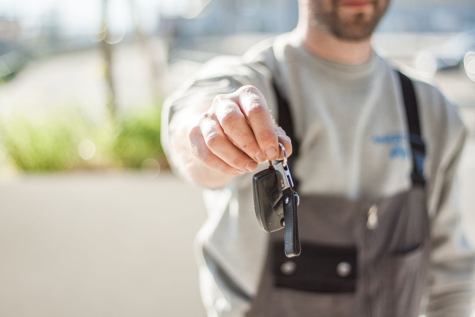 Private seller holding car keys during a used vehicle handoff