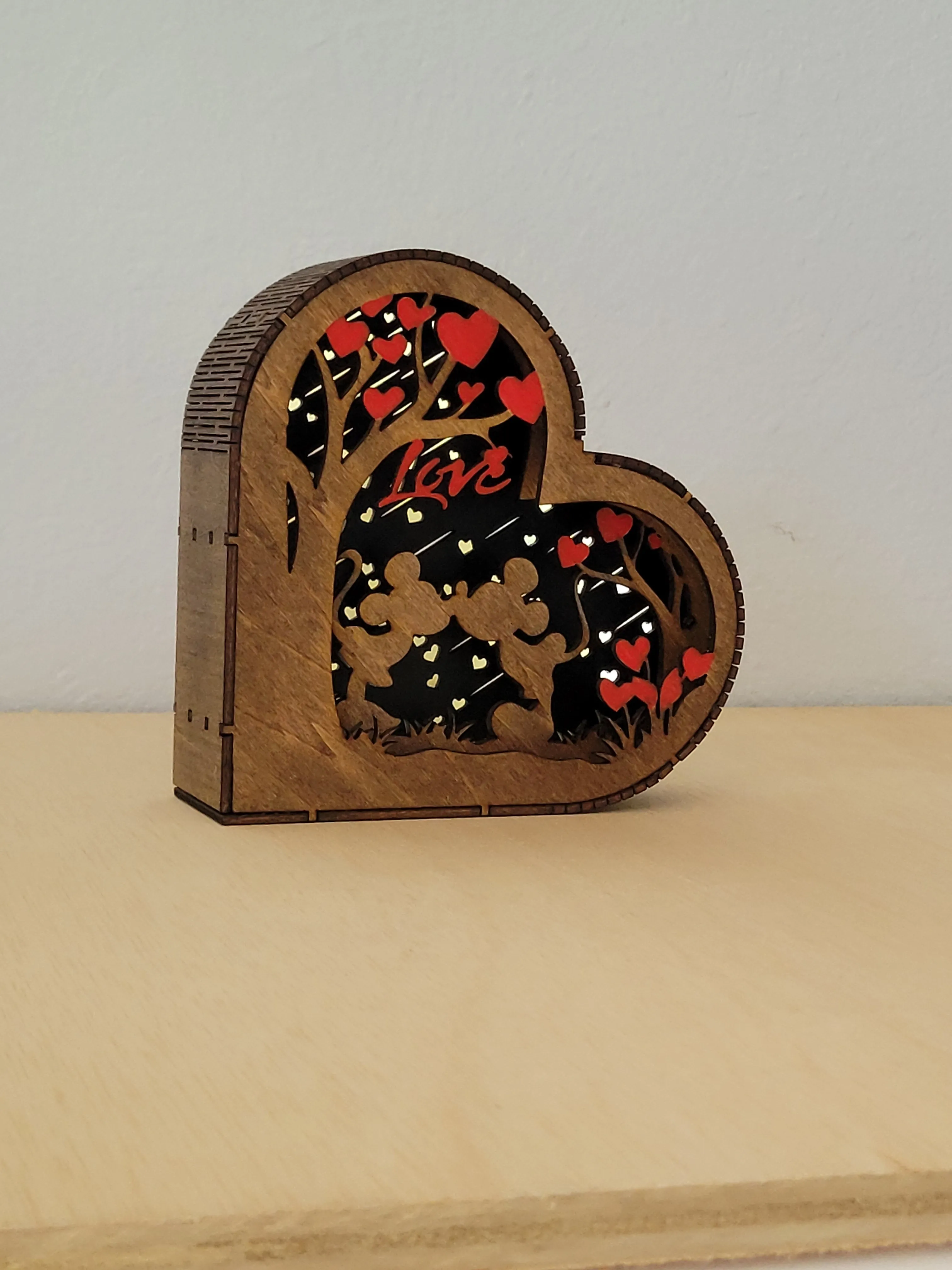 Handmade heart-shaped wooden shadow box with a layered couple design