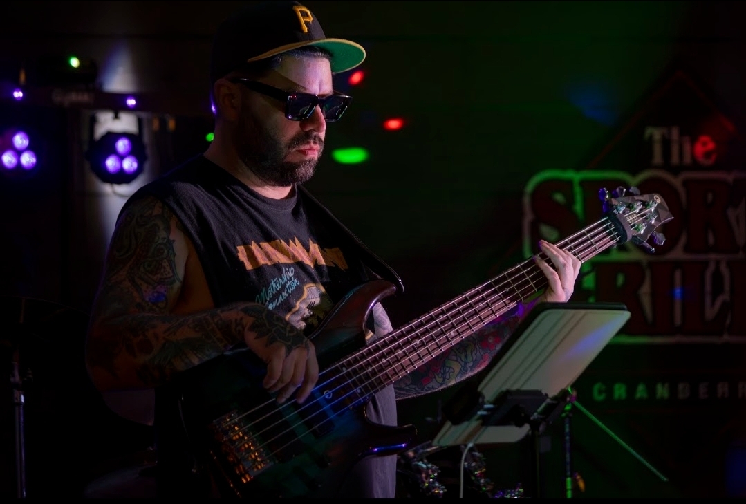 CEC bassist playing beneath stage lights