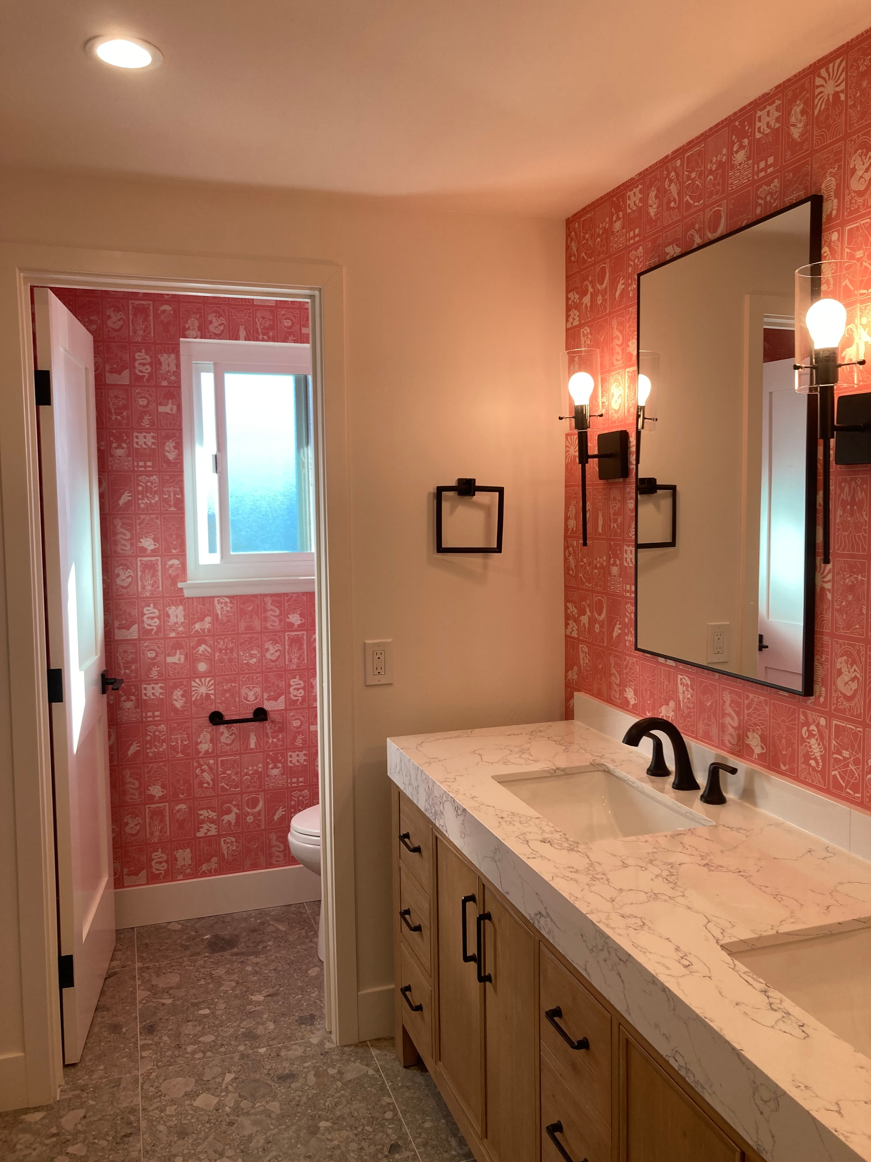 Finished powder room with pink patterned wallpaper