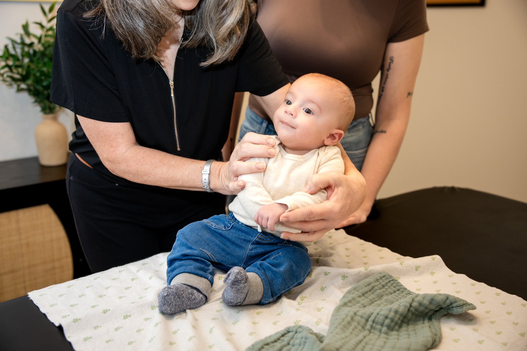 A baby receiving caring support from family