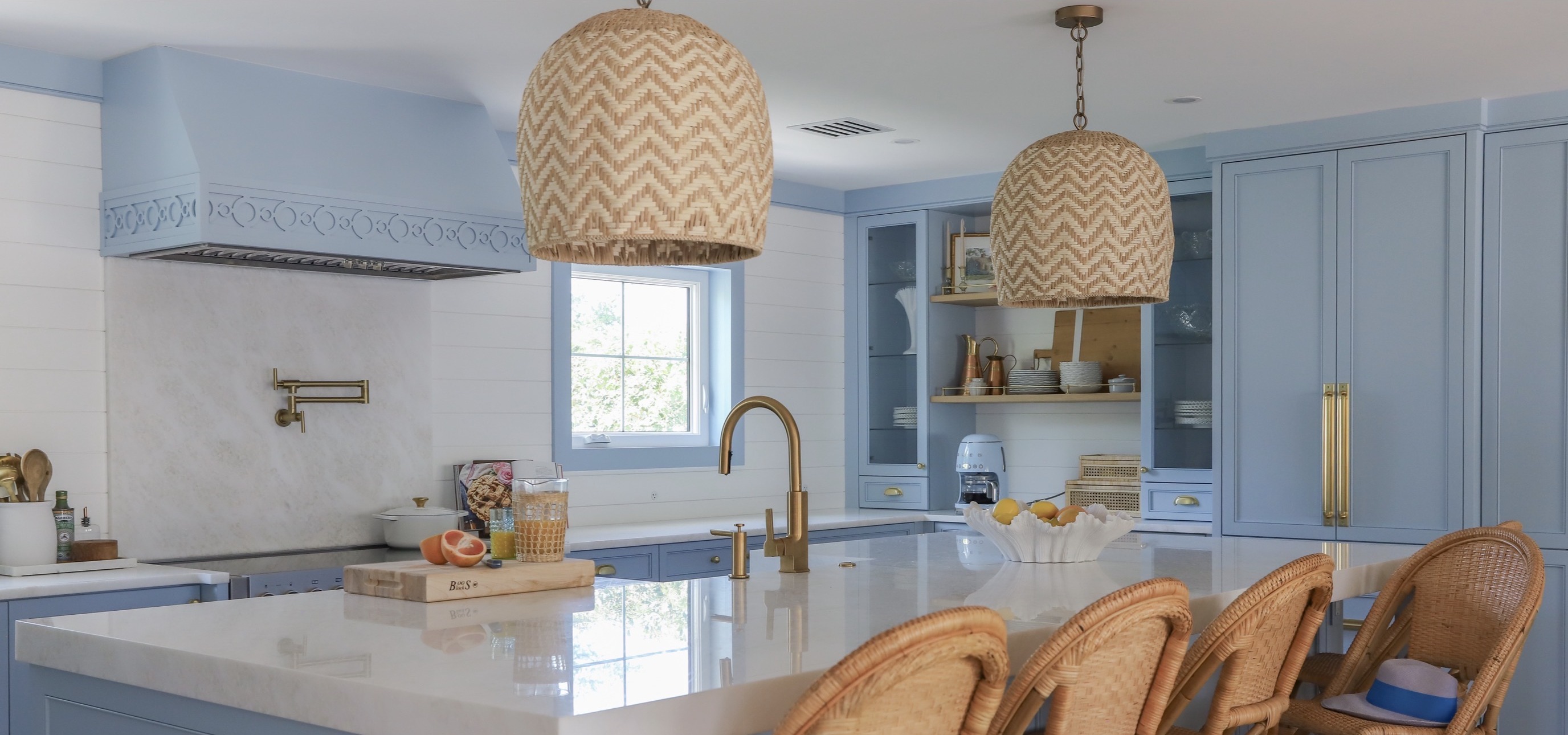Light blue custom kitchen cabinetry with a detailed range hood