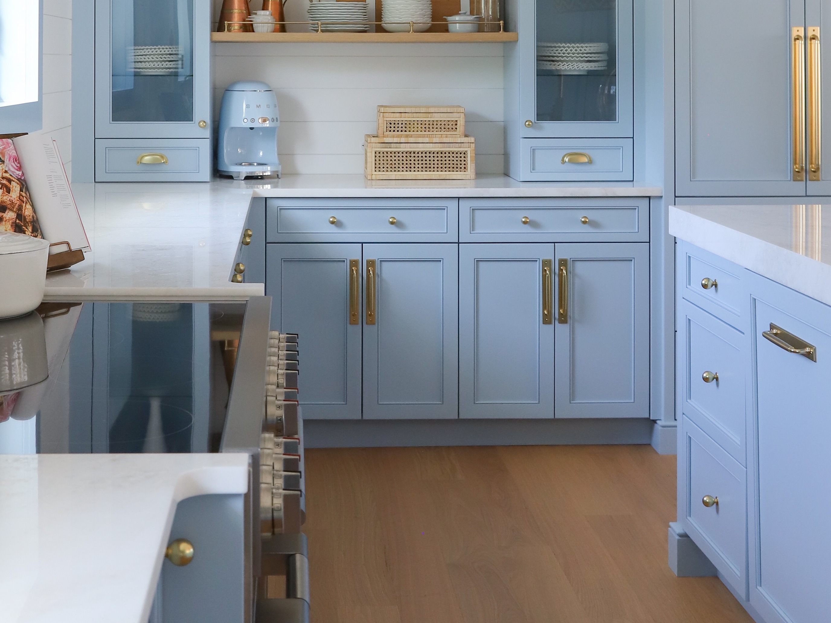 Close view of blue custom cabinetry, brass hardware and tailored storage
