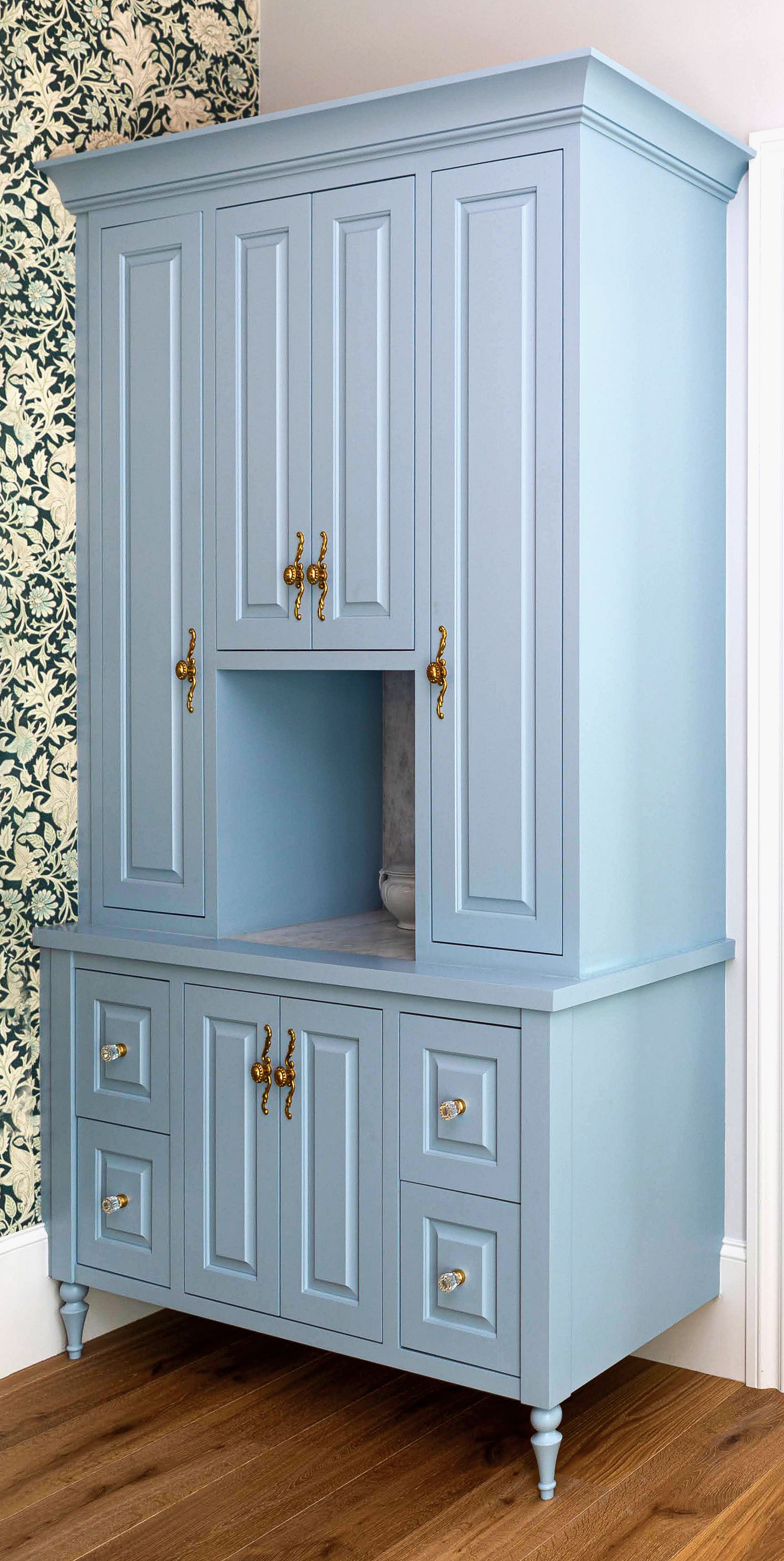 Bespoke pale blue pantry cabinetry with detailed brass hardware and adjustable storage
