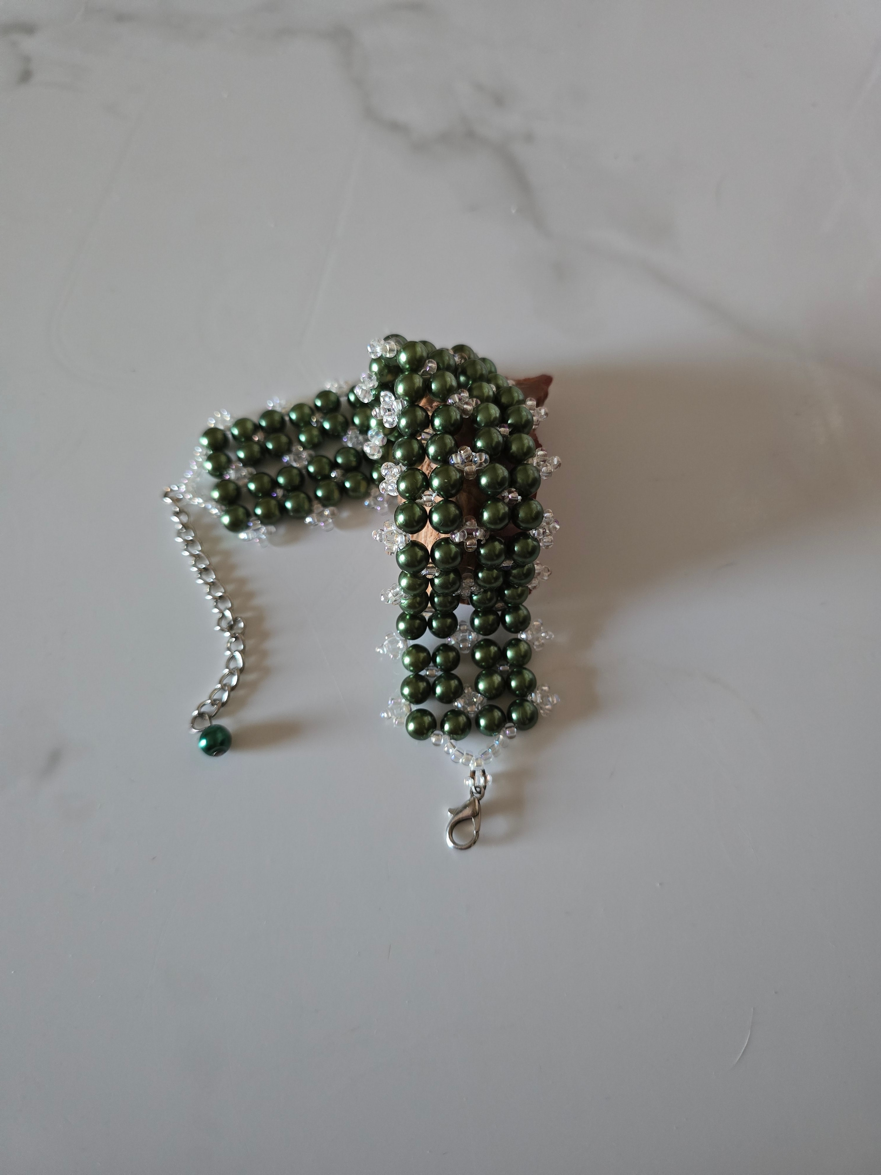 Forest Canopy green glass pearl cuff bracelet curved to show its woven shape