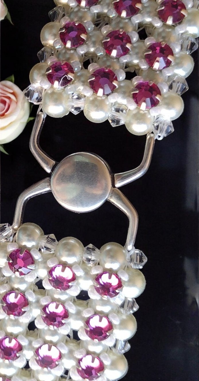 Close view of the choker’s magnetic clasp and fuchsia crystal detail