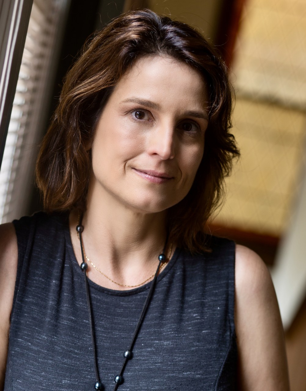 Kim Milone seated beside a sunlit window