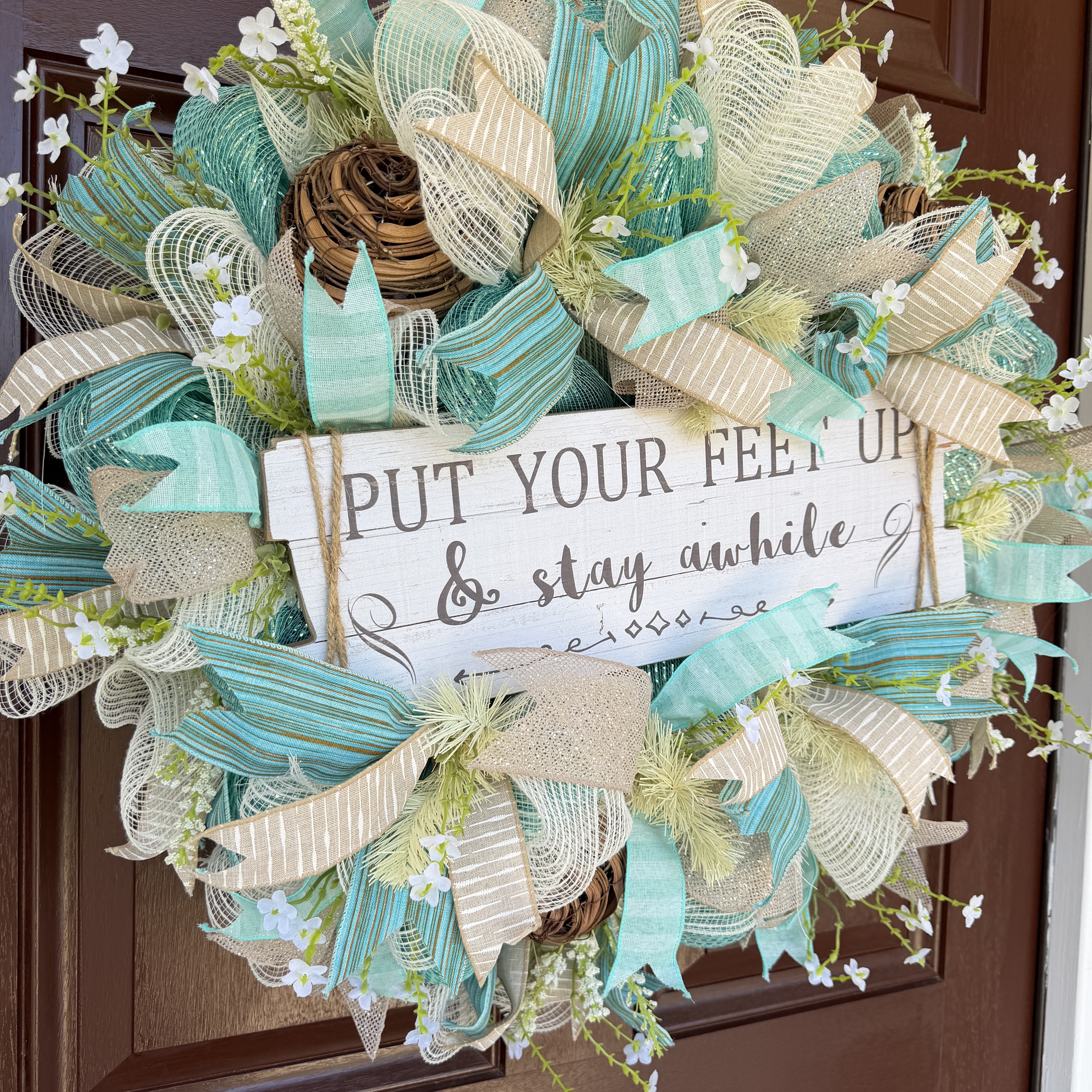 Coastal welcome wreath in aqua, cream, and natural ribbon on a front door