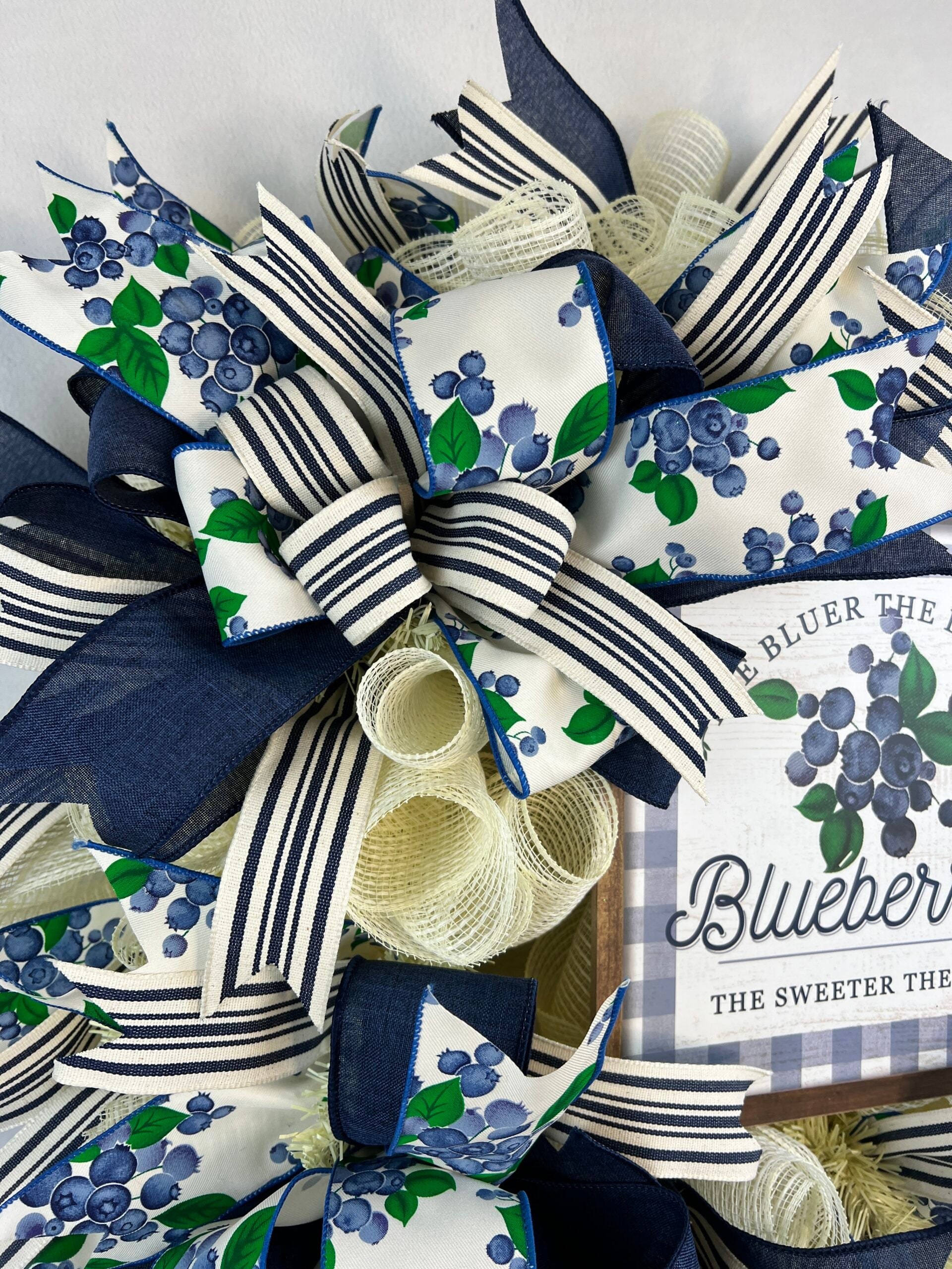 Blue and white wired ribbon bow on a blueberry wreath