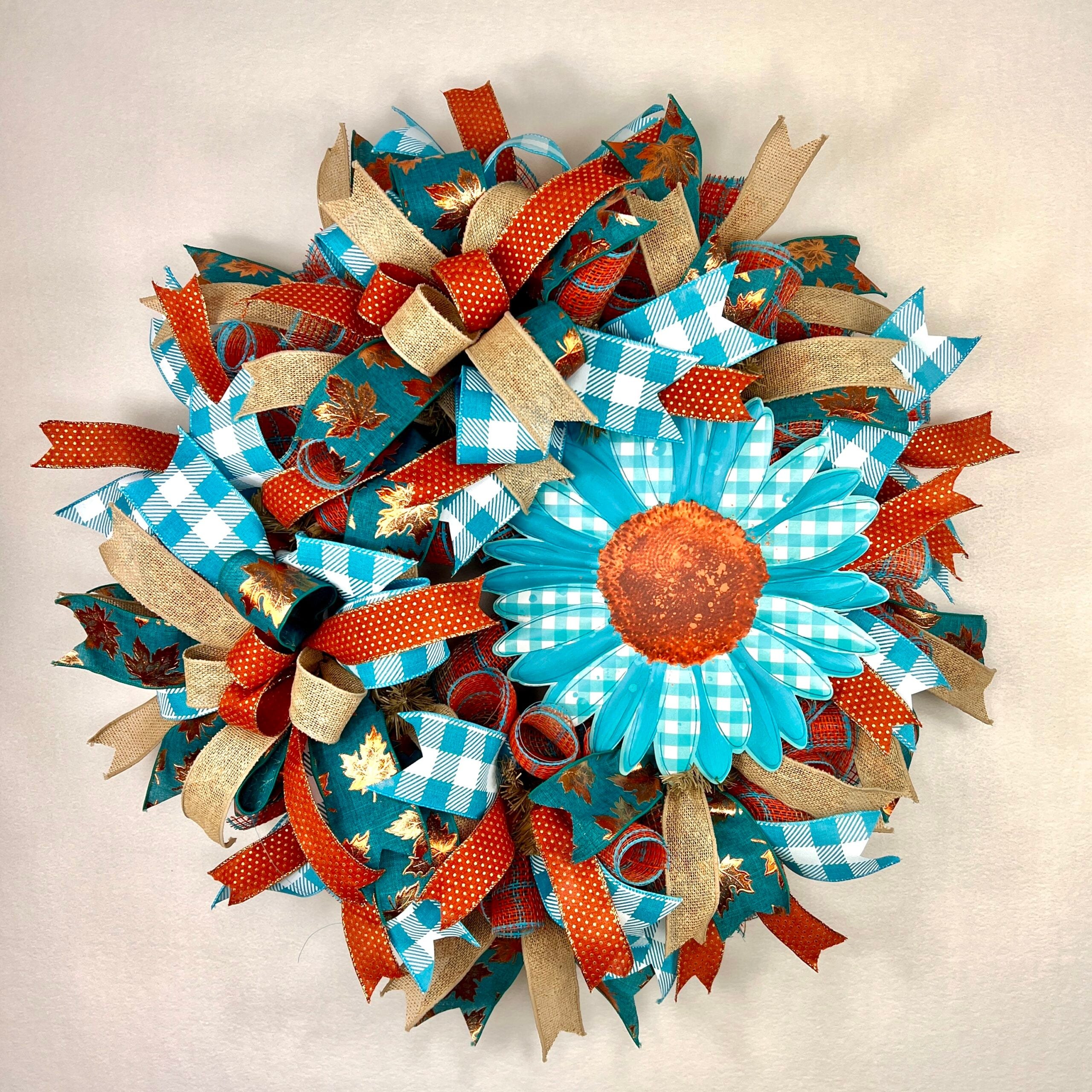 Handmade sunflower wreath with teal, rust, and gold ribbon